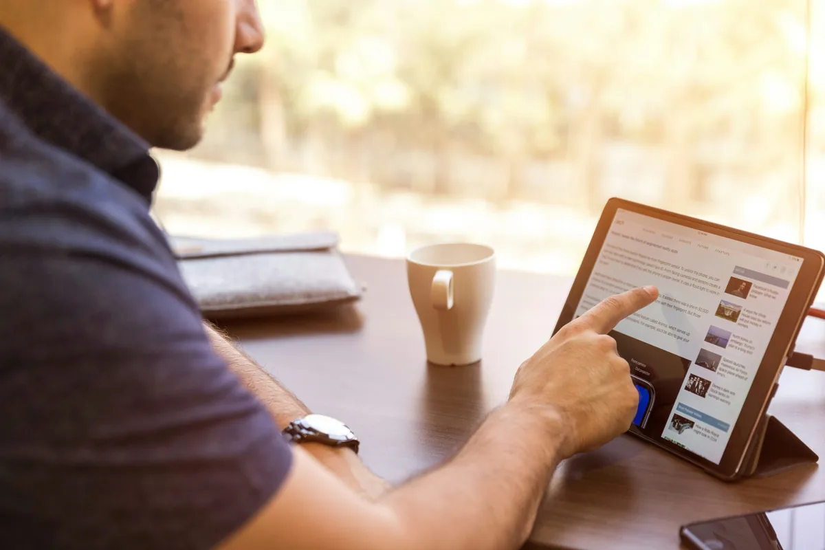 Commercial consultant son fil LinkedIn sur une tablette pour identifier des prospects B2B