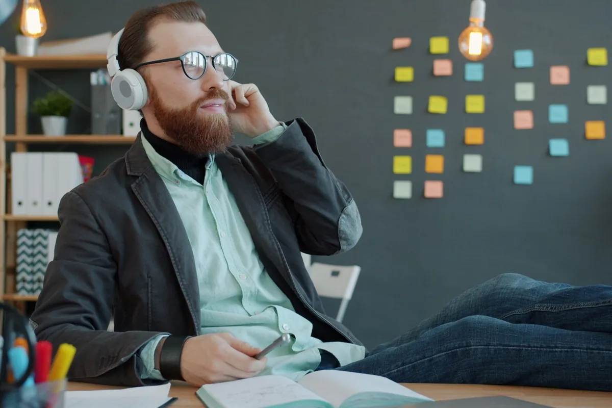 Commercial au casque, en train de réécouter l'enregistrement d'un rendez-vous à son bureau